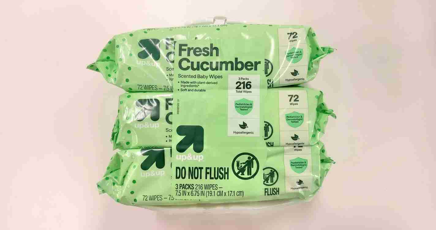 Stack of mint-green Fresh Cucumber scented baby wipes packs with 'DO NOT FLUSH' warning on the packaging.